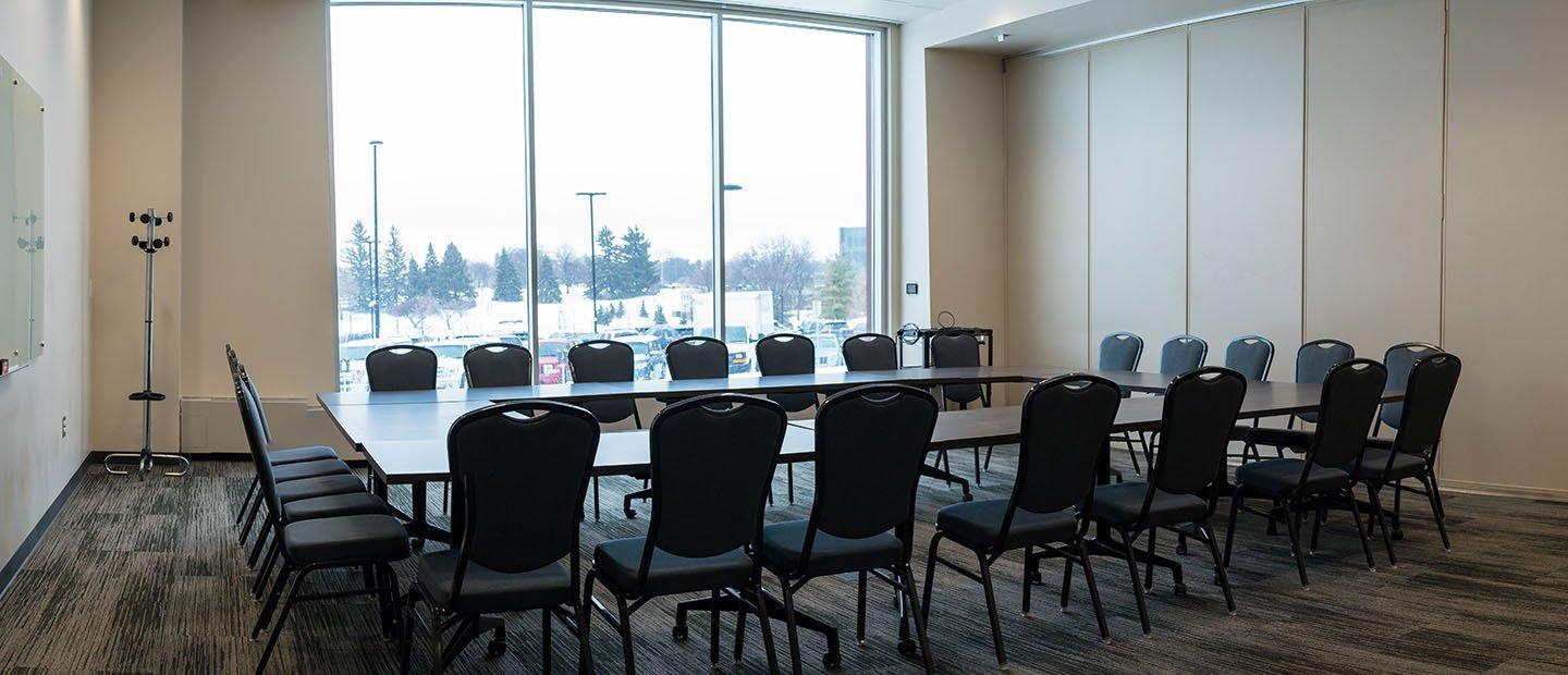 room with a rectangular table and empty chairs arranged around it