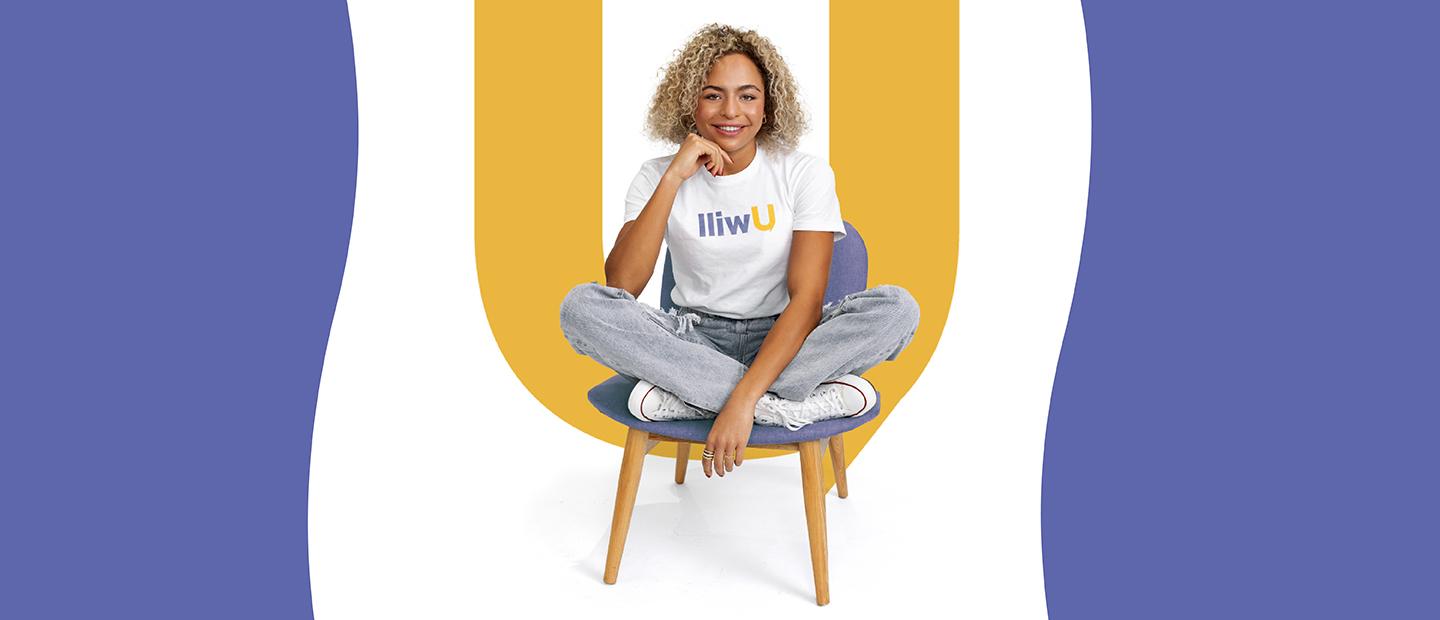 A woman sitting on a stool, wearing a Uwill shirt