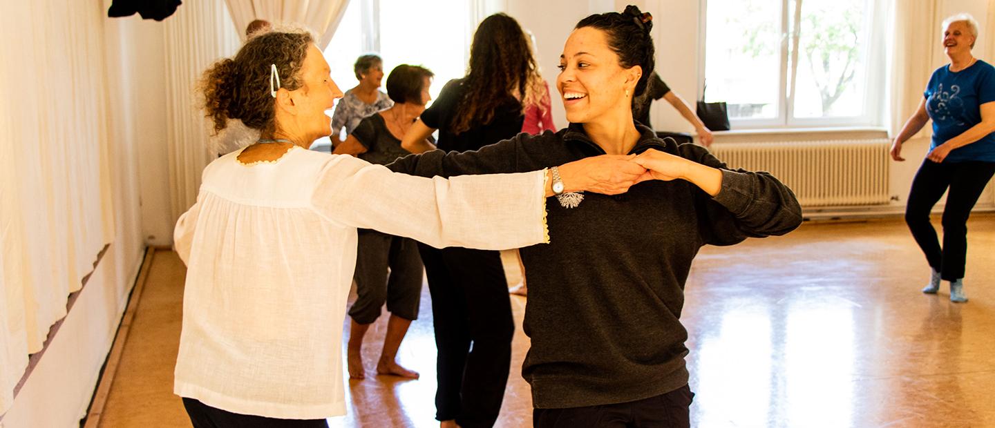 image of two women dancing together, smiling